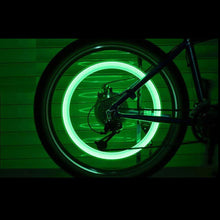 Bicycle wheel with glowing green rim on a dark background